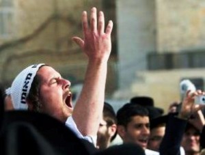 An ultra-Orthodox Jewish man gestures and shouts in protest against a monthly prayer session of the Women of the Wall group at the Western Wall in Jerusalem's Old City June 9, 2013. The Women of the Wall group has angered ultra-Orthodox Jews by wearing prayer shawls and reading from holy scriptures at the Western Wall, a revered remnant of the Biblical Jewish Temple. Orthodox Jewish tradition reserves such rituals for men, and some more conservative rabbis have vowed to battle a plan devised by a former cabinet minister to try to accommodate the women's more liberal approach to prayer. REUTERS/Ronen Zvulun (JERUSALEM - Tags: RELIGION POLITICS CIVIL UNREST) - RTX10H5N